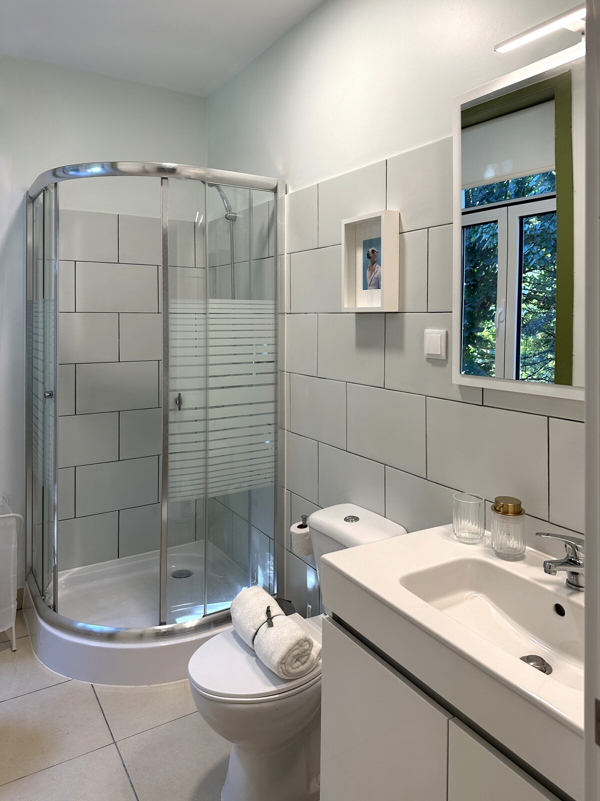 Bathroom with curved shower and window