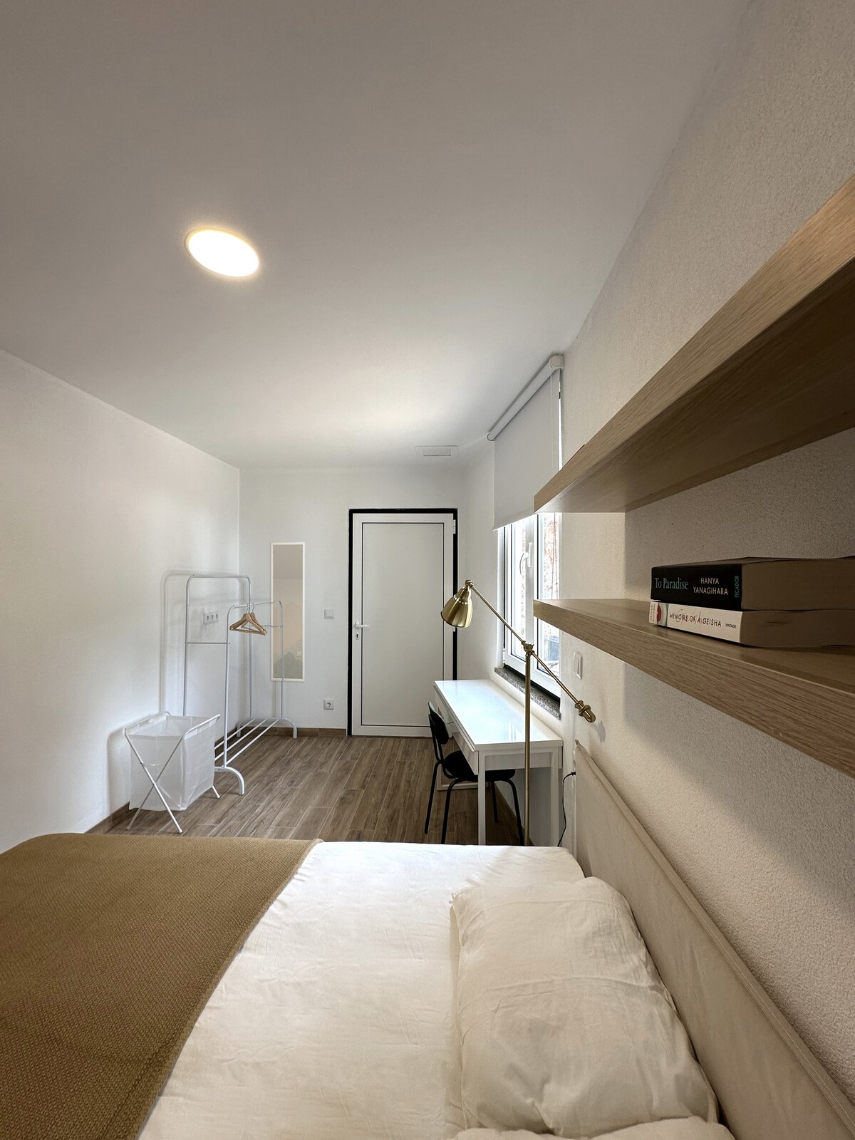 Long bedroom with desk and shelves