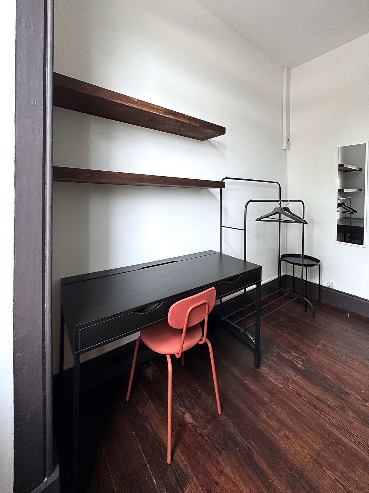 Black desk with red chair and shelves
