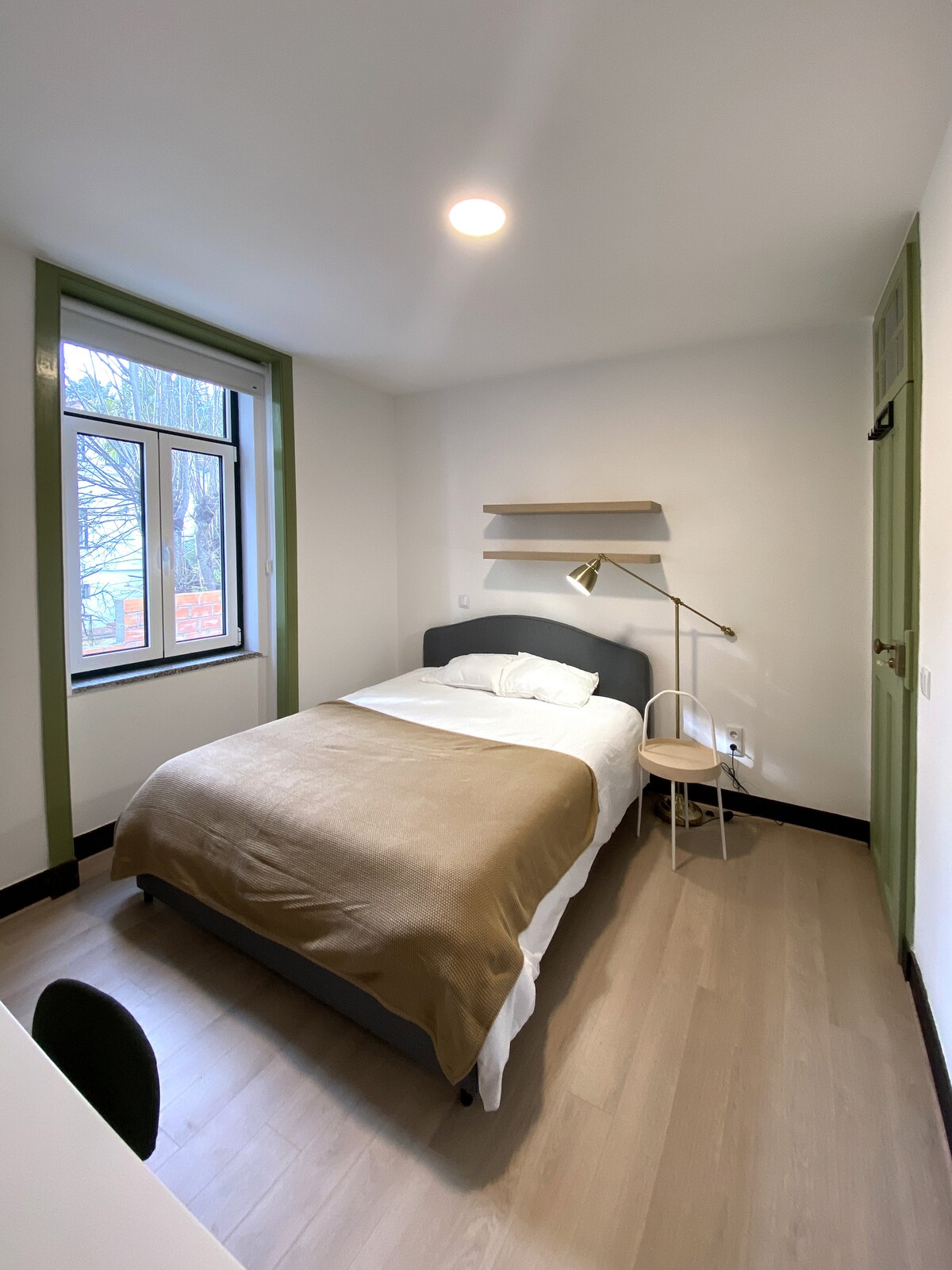 Bedroom with green window trim and single bed