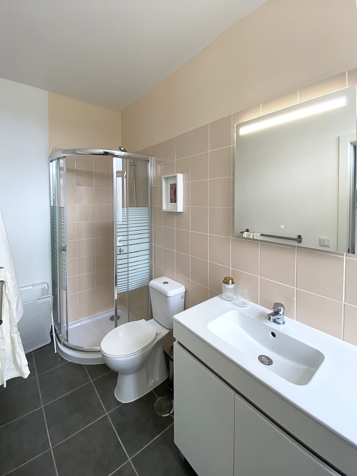 Bathroom with pink tiles and rounded shower