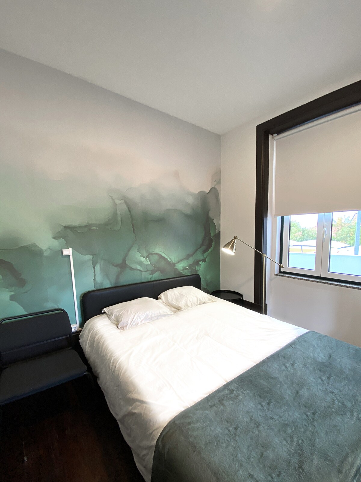 Bedroom with watercolor mural and green throw